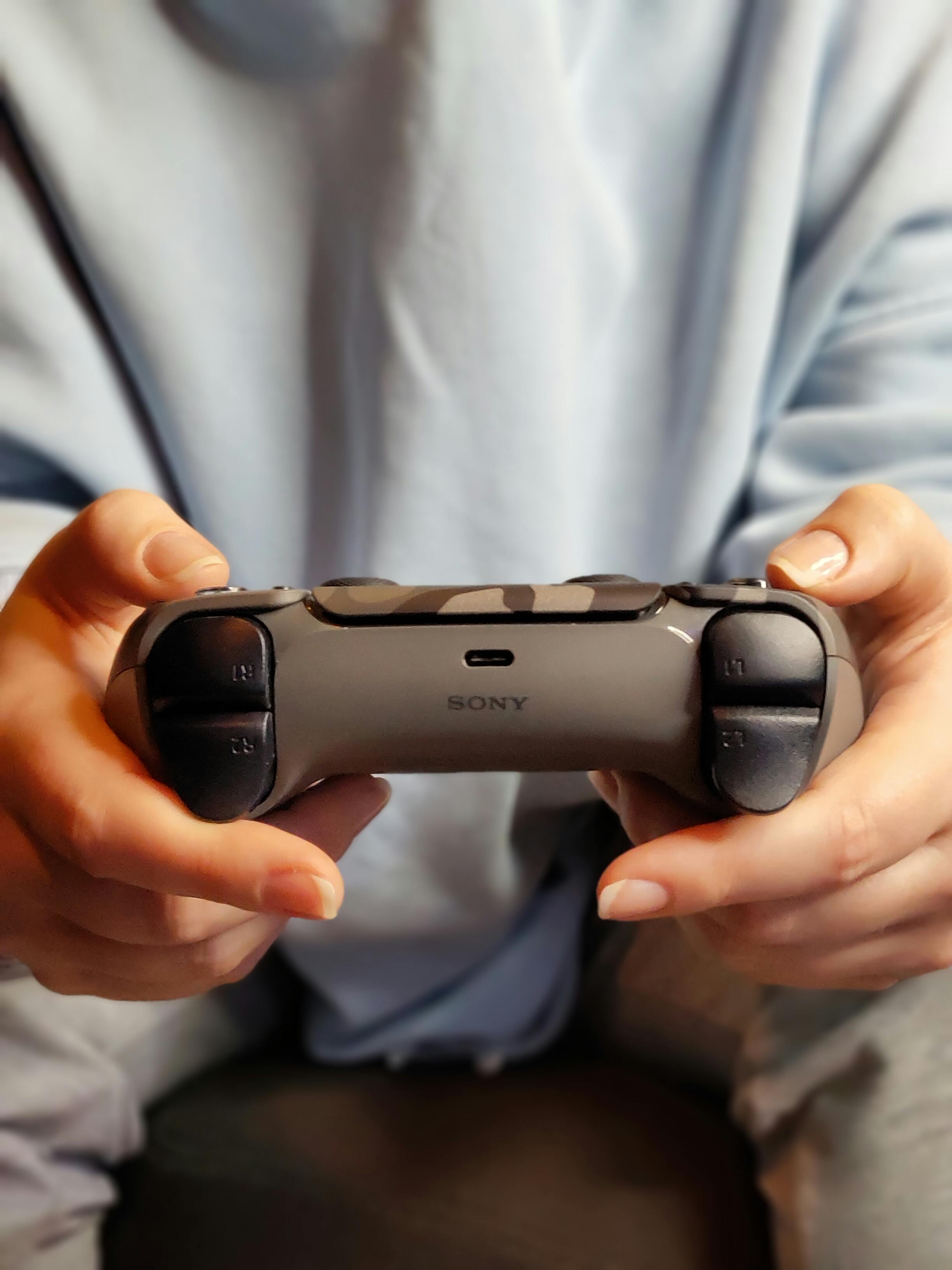 Person spielt mit PS5 Controller